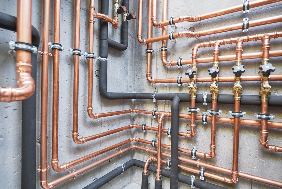 Réseau de tuyauterie sur un mur de béton